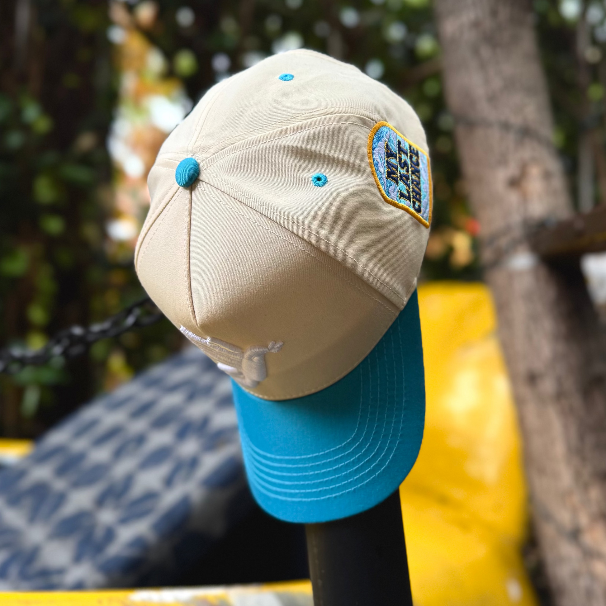 Beige cap with blue brim on a yellow vehicle with blurred greenery in the background